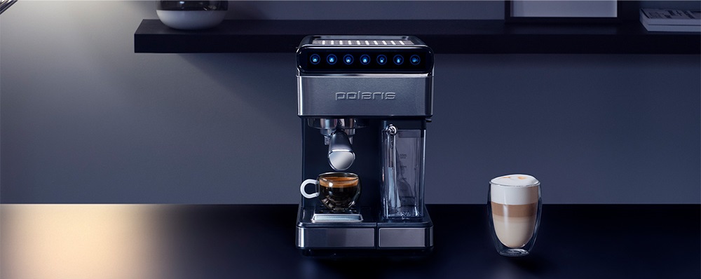 Polaris PCM 1535E Adore Cappuccino стоит на столе рядом с чашкой кофе